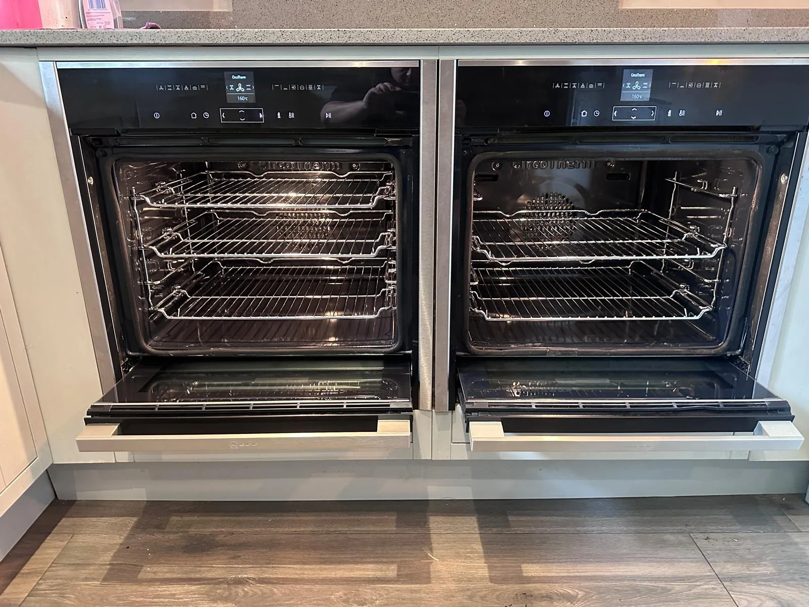 Two clean open NEFF Slide&Hide ovens with shelves in place in Hereford